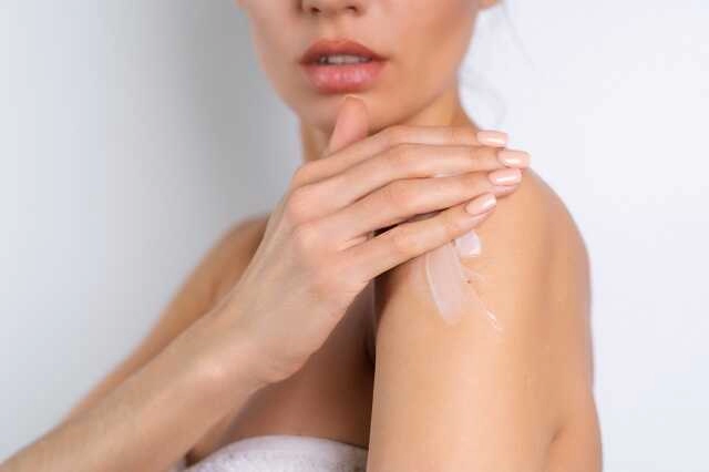 Kobieta używa balsamu nawilżającego do suchej skóry